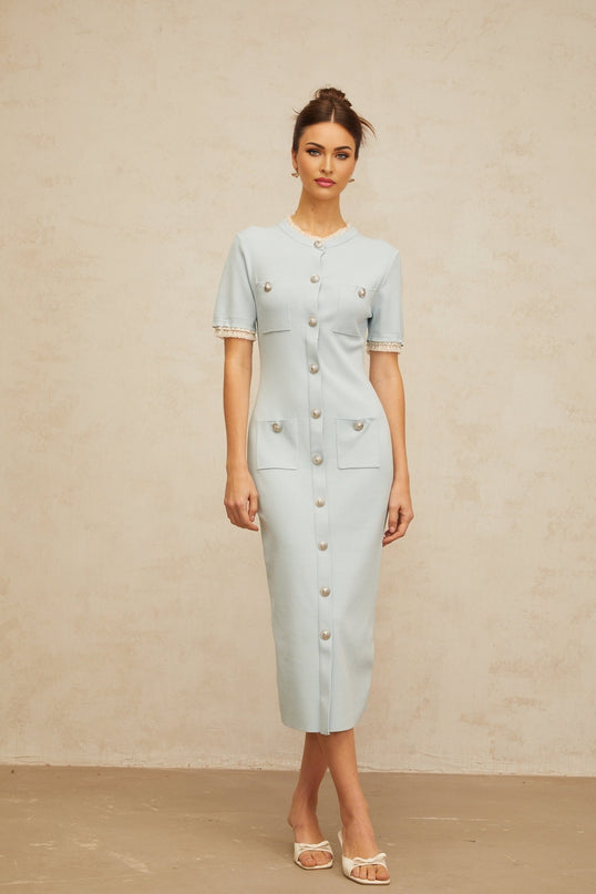 A light blue knitted midi dress with a pencil silhouette worn by a model standing against a plain background