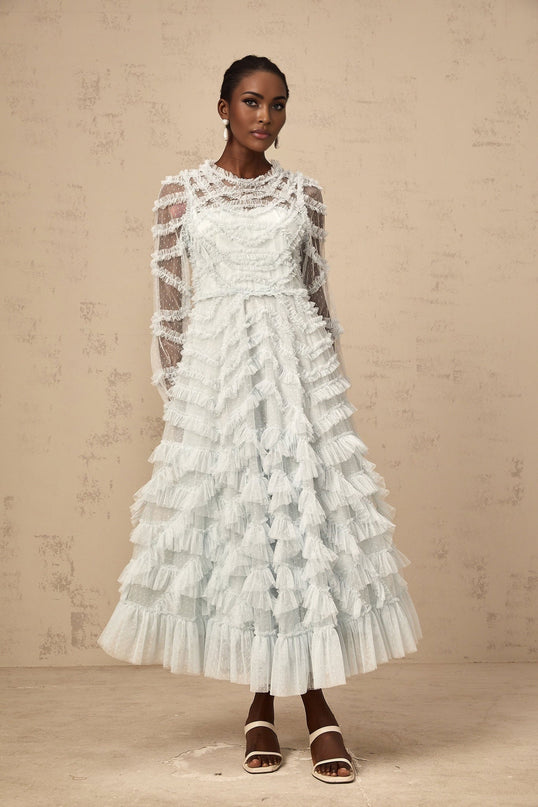 A light blue midi dress with ruffled details and small white polka dots featuring a feminine silhouette and delicate design elements