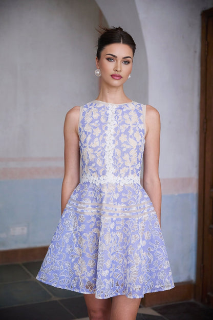 A light blue mini dress with crochet lace detailing and puff sleeves on a white background