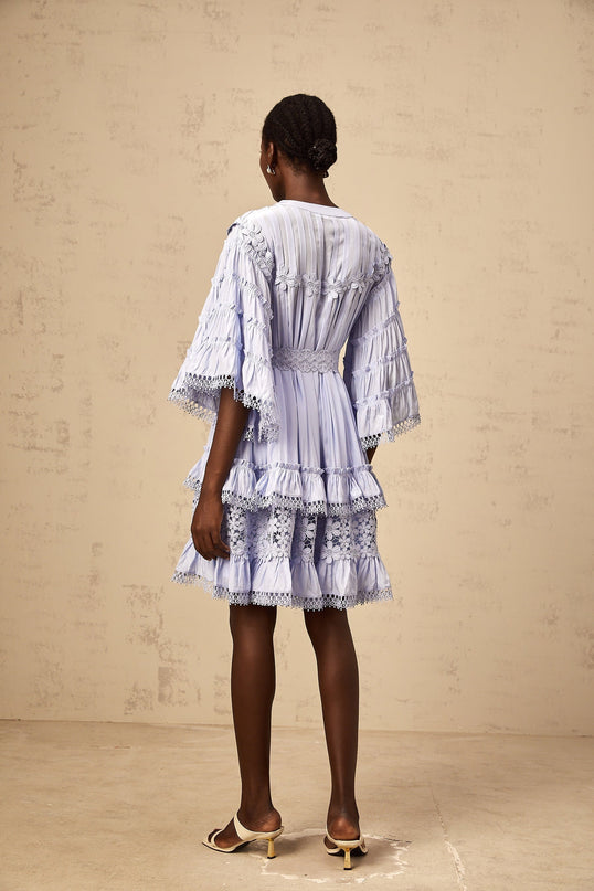 A light blue mini dress with tiered layers and delicate floral embroidery details designed by Gaelle