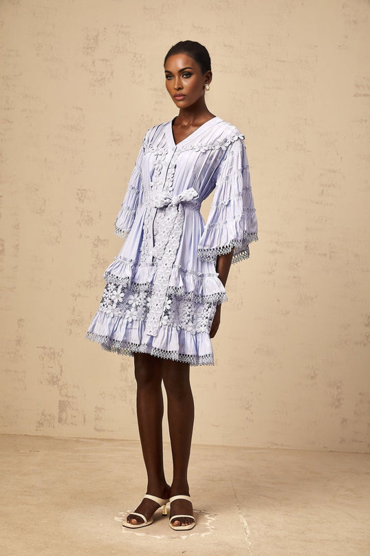A light blue mini dress with tiered layers and delicate floral embroidery details throughout the fabric