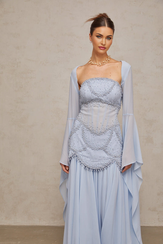 A light blue pleated maxi dress with faux pearl embellishments by Gaelle
