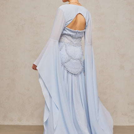 A light blue pleated maxi dress with faux pearl embellishments styled on a mannequin or model against a plain background