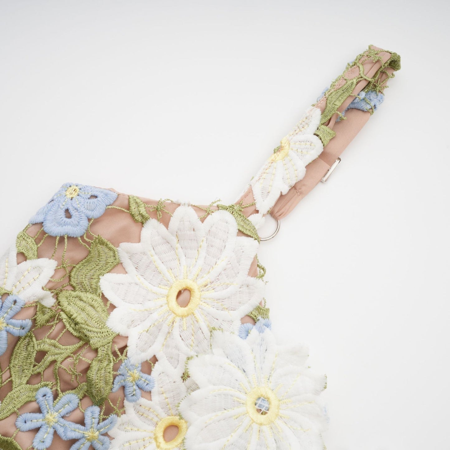 A lightcolored midi dress with floral embroidery and hollowcarved details featuring a feminine silhouette and delicate design elements