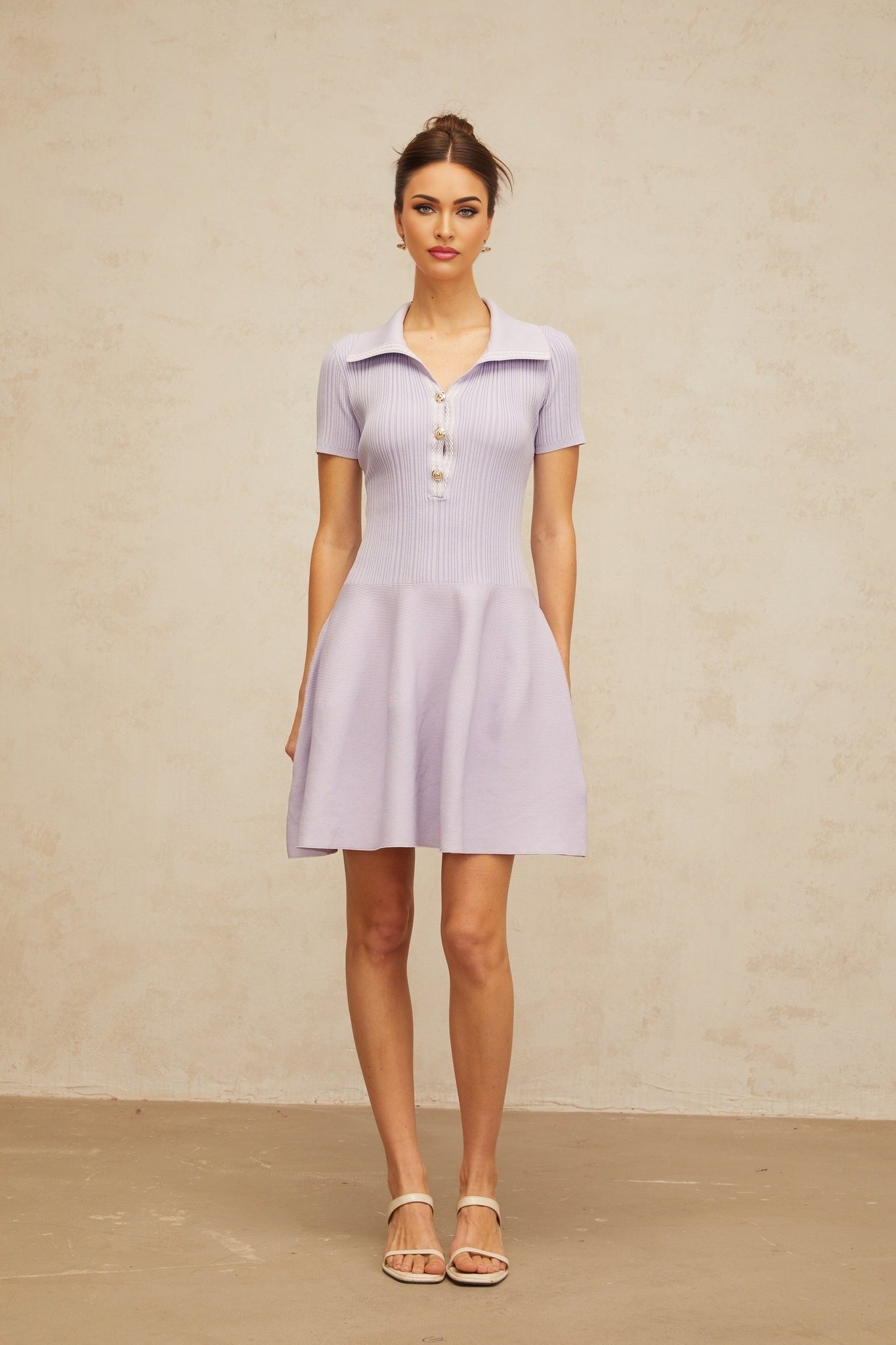 A lilac colored mini dress with a flared skirt and shirred bodice made of knit fabric named Vanessa