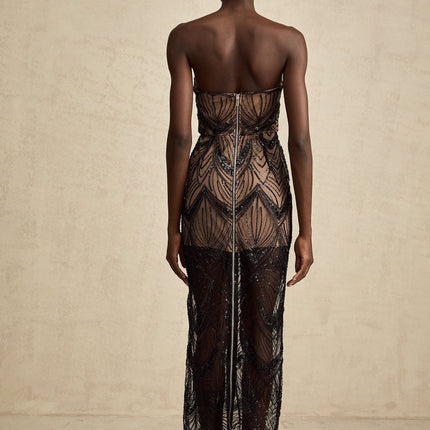 A long black maxi dress with a corset bodice covered in shimmering sequins and sheer mesh detailing