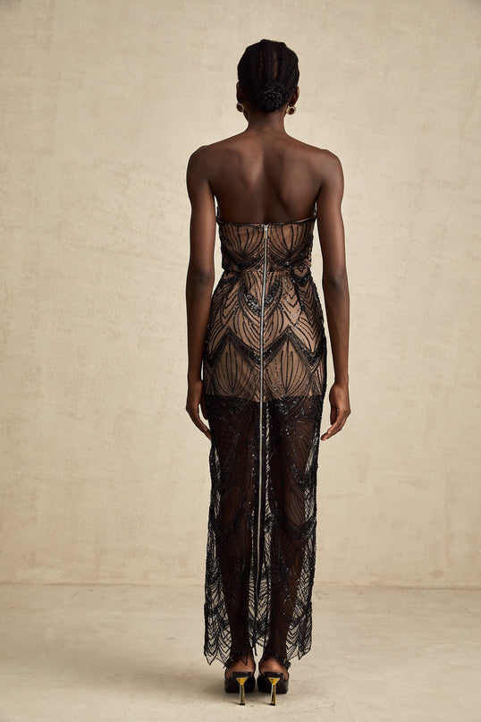 A long black maxi dress with a corset bodice covered in shimmering sequins and sheer mesh detailing