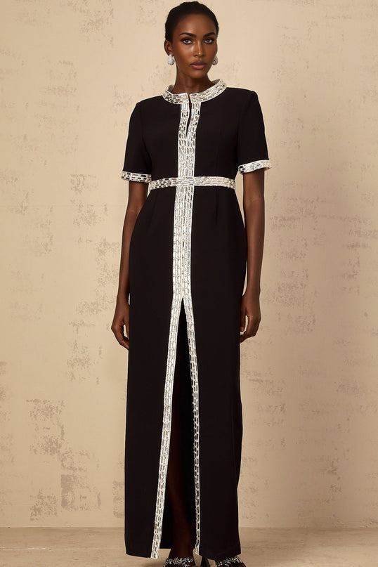 A long black maxi dress with a front slit and crystal embellishments worn by a model