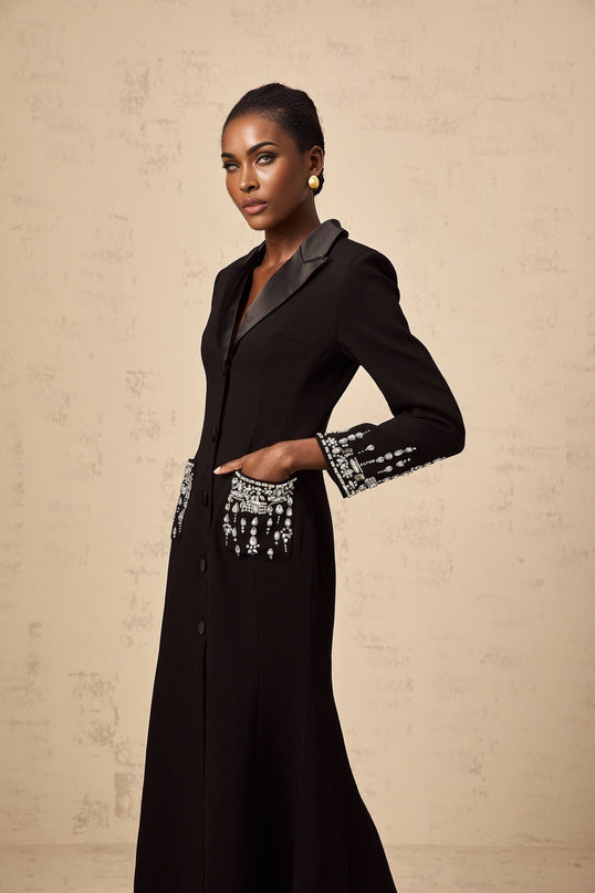 A long black maxi dress with blazer style top featuring embellishments and a fitted silhouette suitable for formal occasions
