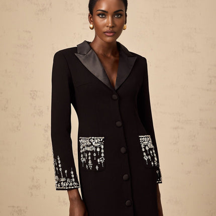 A long black maxi dress with blazer style top featuring embellishments worn by a model