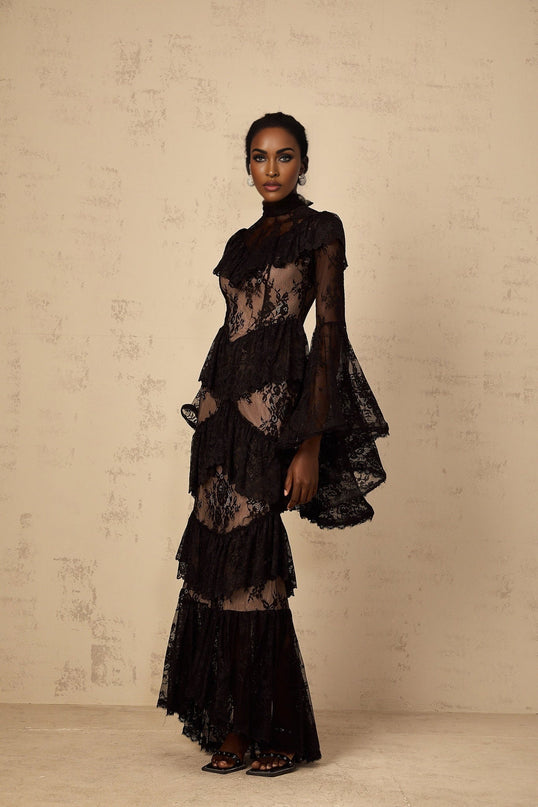 A long black maxi dress with floral lace details and ruffled accents throughout the design