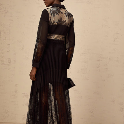 A long black maxi dress with pleated skirt and floral lace panels featuring a feminine silhouette and elegant design