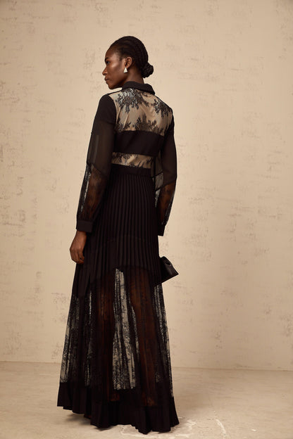 A long black maxi dress with pleated skirt and floral lace panels featuring a feminine silhouette and elegant design