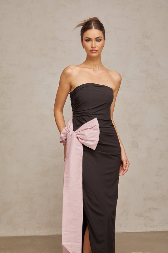 A long black offshoulder maxi dress with a bow detail at the neckline worn by a model