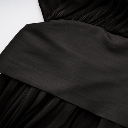 A long black pleated satin maxi dress with a flowing silhouette on a plain background