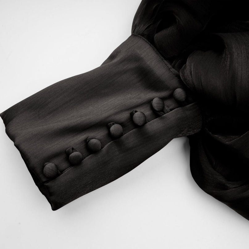 A long black satin maxi dress with pleated detailing named Mila