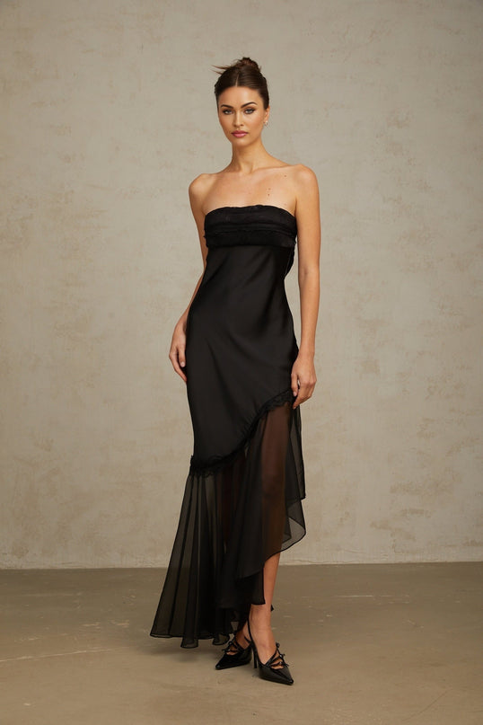 A long black satin maxi dress with sheer tulle panels elegant evening gown with fitted bodice and flowing skirt