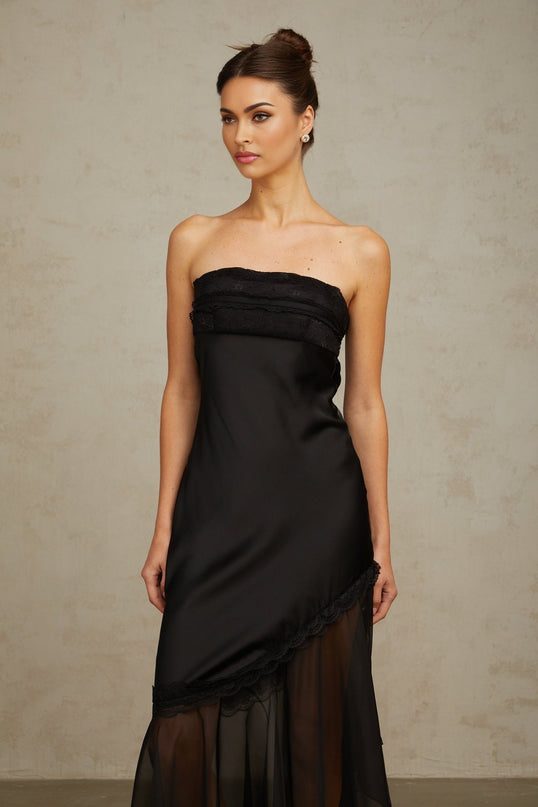 A long black satin maxi dress with sheer tulle panels elegant formal evening gown with fitted bodice and flowing skirt