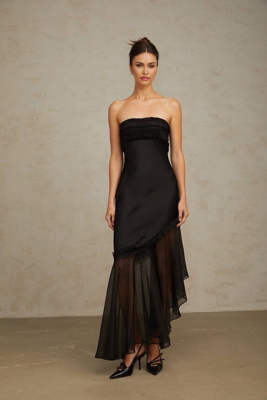 A long black satin maxi dress with sheer tulle panels featuring a flowing silhouette and elegant design