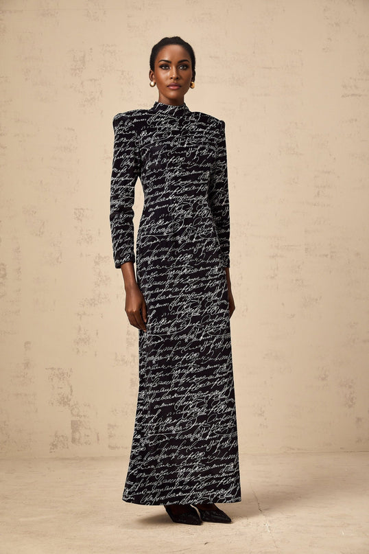 A long black velvet maxi dress with jade colored letter print design