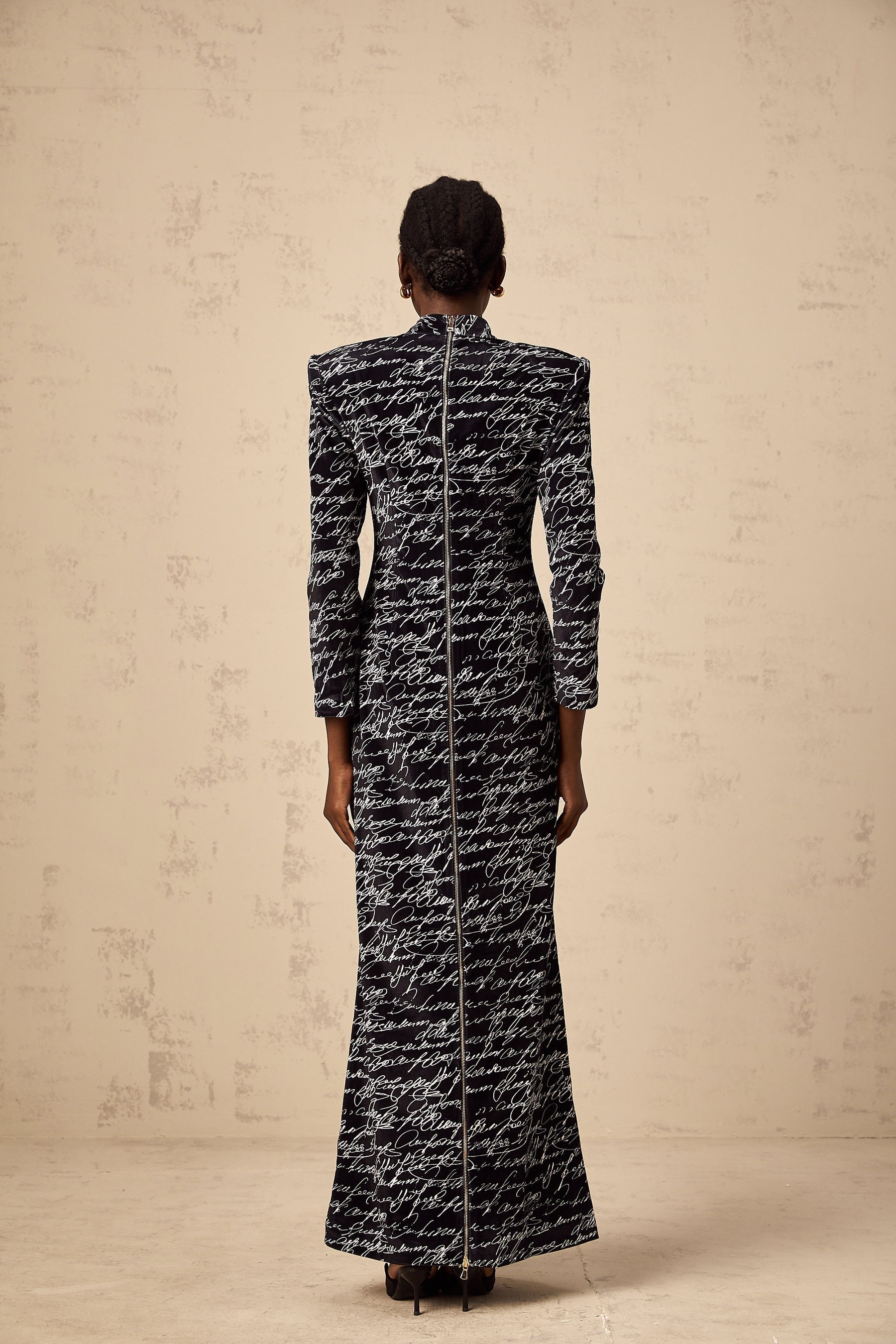 A long black velvet maxi dress with jade colored letter print design