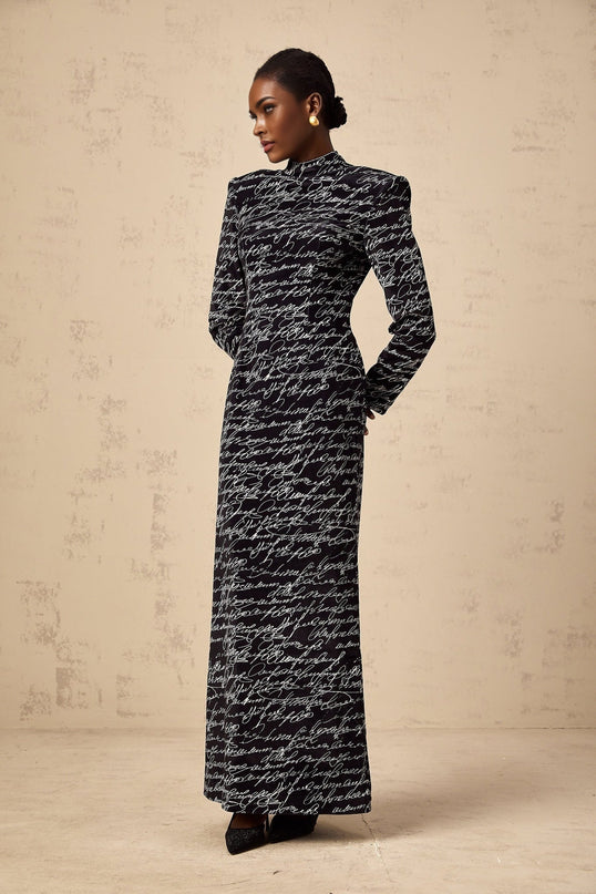 A long black velvet maxi dress with jade green lettering printed on it