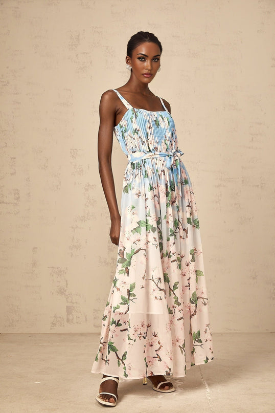 A long blue maxi dress with a floral print pattern and pleated design