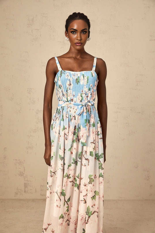 A long blue maxi dress with a floral print pattern and pleated design