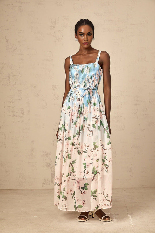 A long blue maxi dress with a floral print pattern and pleated design
