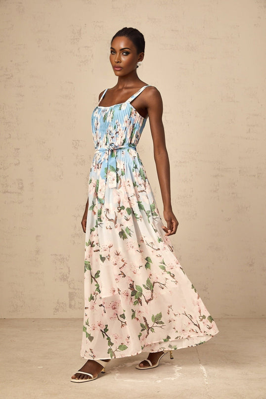 A long blue maxi dress with a floral print pattern and pleated design