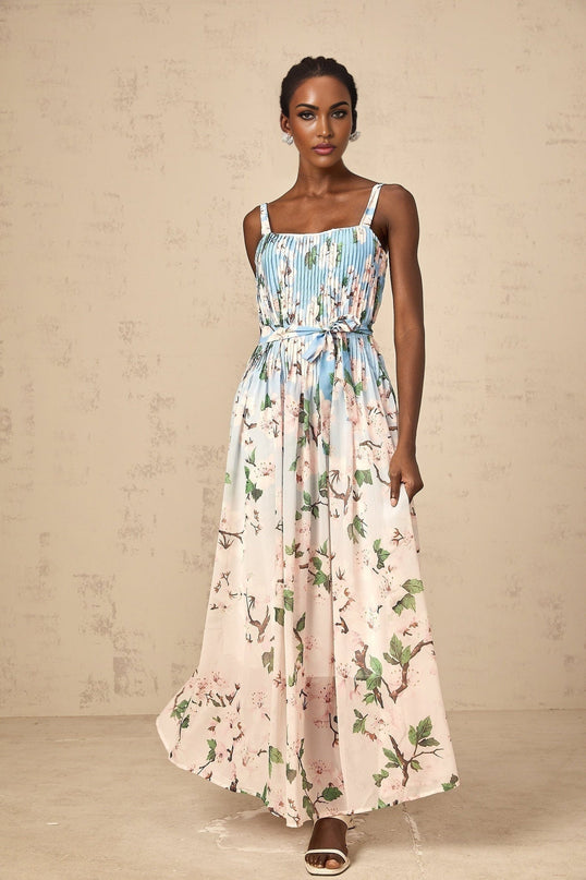 A long blue maxi dress with a floral print pattern and pleated design