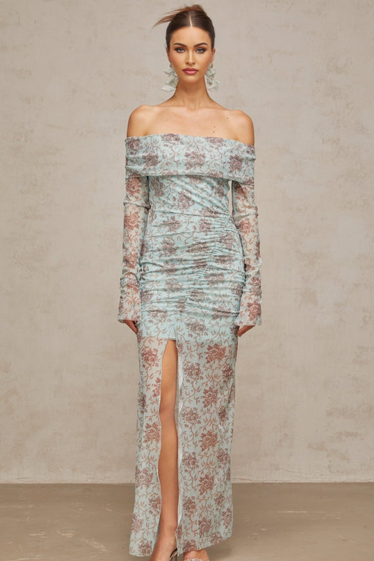 A long blue maxi dress with a floral print pattern and ruched detailing throughout the garment