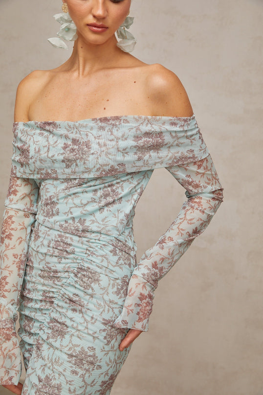 A long blue maxi dress with a floral print pattern and ruched detailing