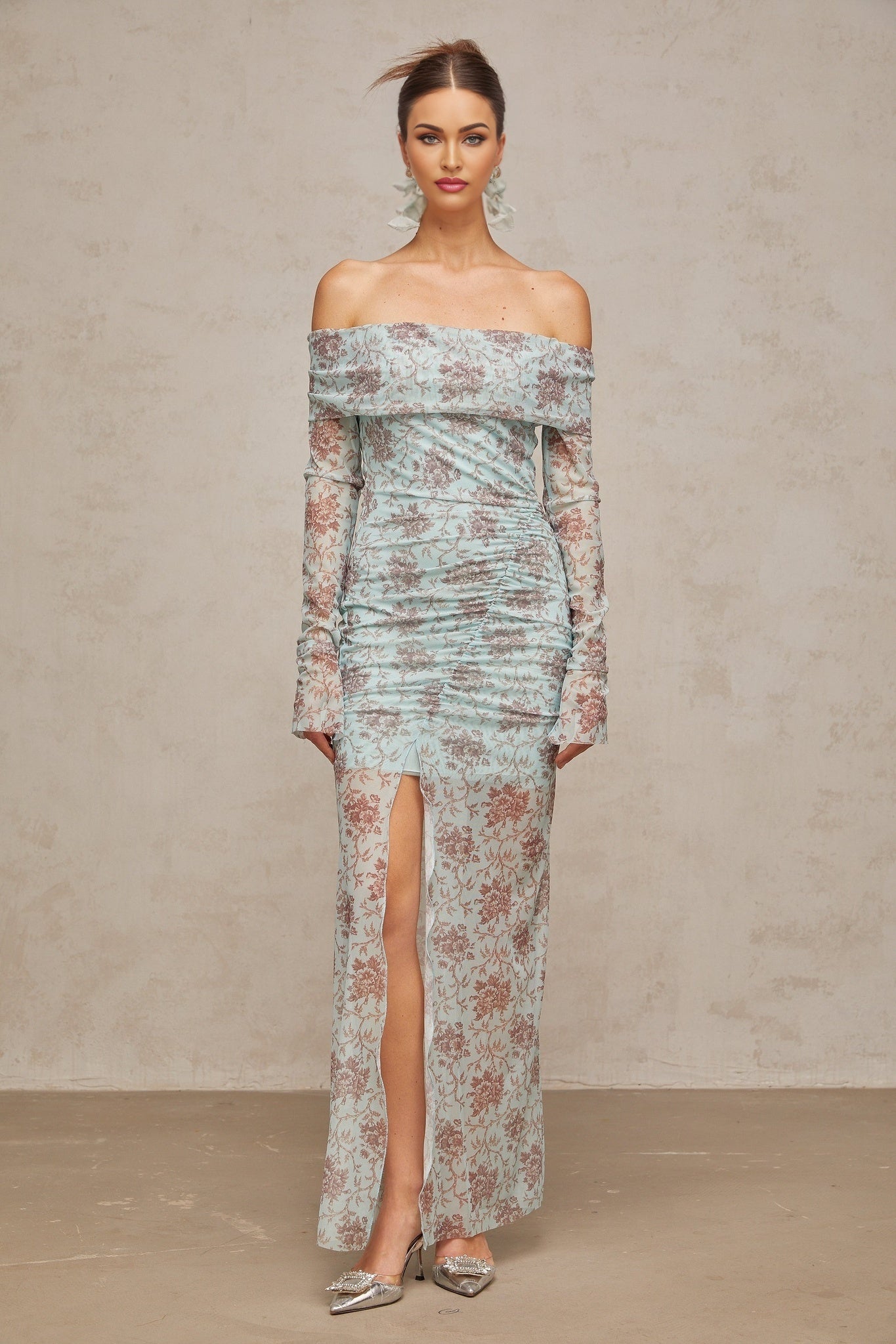 A long blue maxi dress with a floral print pattern and ruched detailing