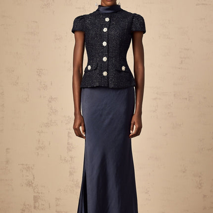 A long blue maxi dress with a peplum waist and paneled design featuring a fitted bodice and flowing skirt