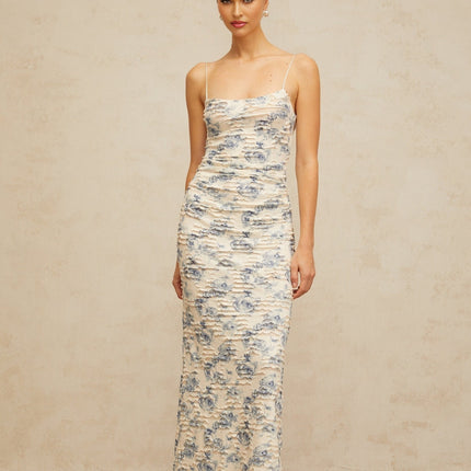 A long blue maxi dress with a textured floral print pattern covering the entire garment