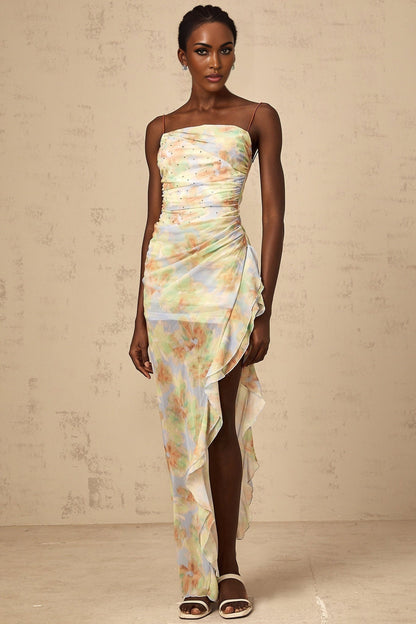 A long blue maxi dress with an asymmetric design featuring a floral print pattern and ruched detailing