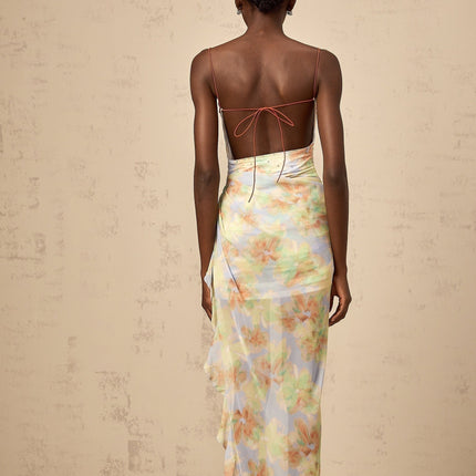 A long blue maxi dress with an asymmetric design featuring a floral print pattern and ruched details