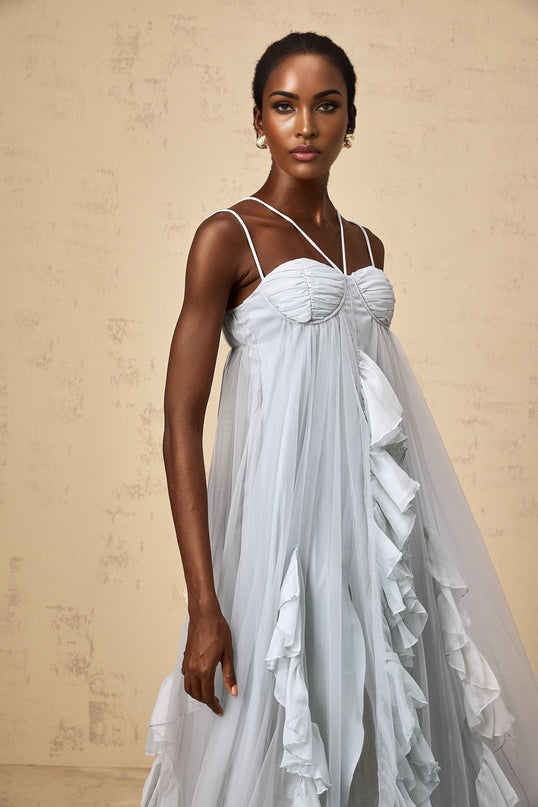A long blue maxi dress with multiple layers of ruffled tulle creating a flowing and ethereal appearance