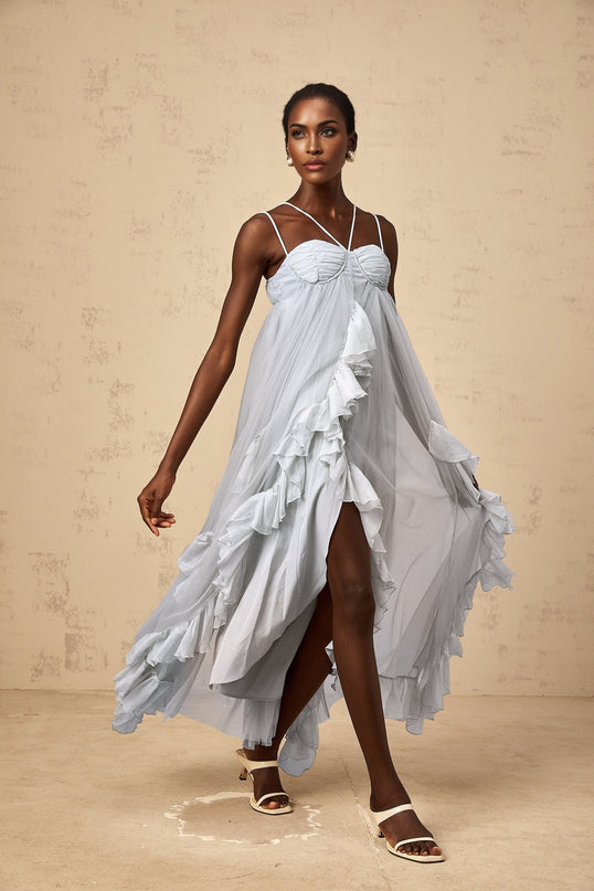 A long blue maxi dress with multiple layers of ruffled tulle fabric creating a flowy silhouette