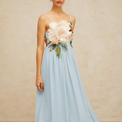 A long blue maxi dress with shirred detailing and floral embroidery pattern named Josette