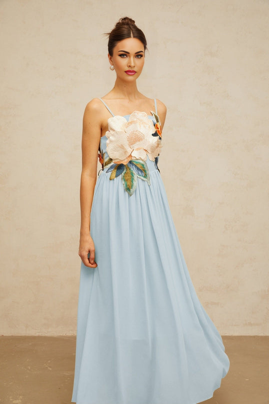 A long blue maxi dress with shirred detailing and floral embroidery pattern named Josette
