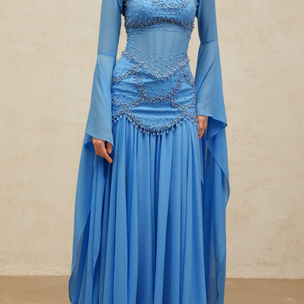 A long blue pleated maxi dress adorned with faux pearl embellishments