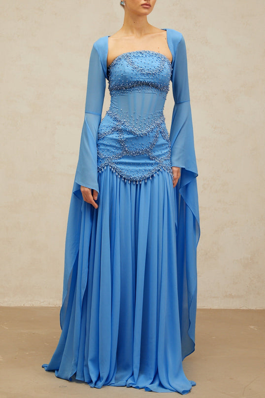 A long blue pleated maxi dress adorned with faux pearl embellishments