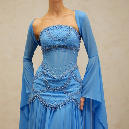 A long blue pleated maxi dress with faux pearl embellishments by Gaelle