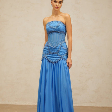 A long blue pleated maxi dress with faux pearl embellishments by Gaelle