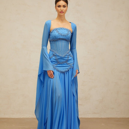 A long blue pleated maxi dress with faux pearl embellishments by Gaelle