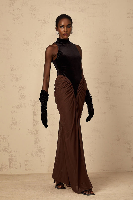 A long brown dress with velvet panels and ruched detailing named Mathilde shown on a full length view