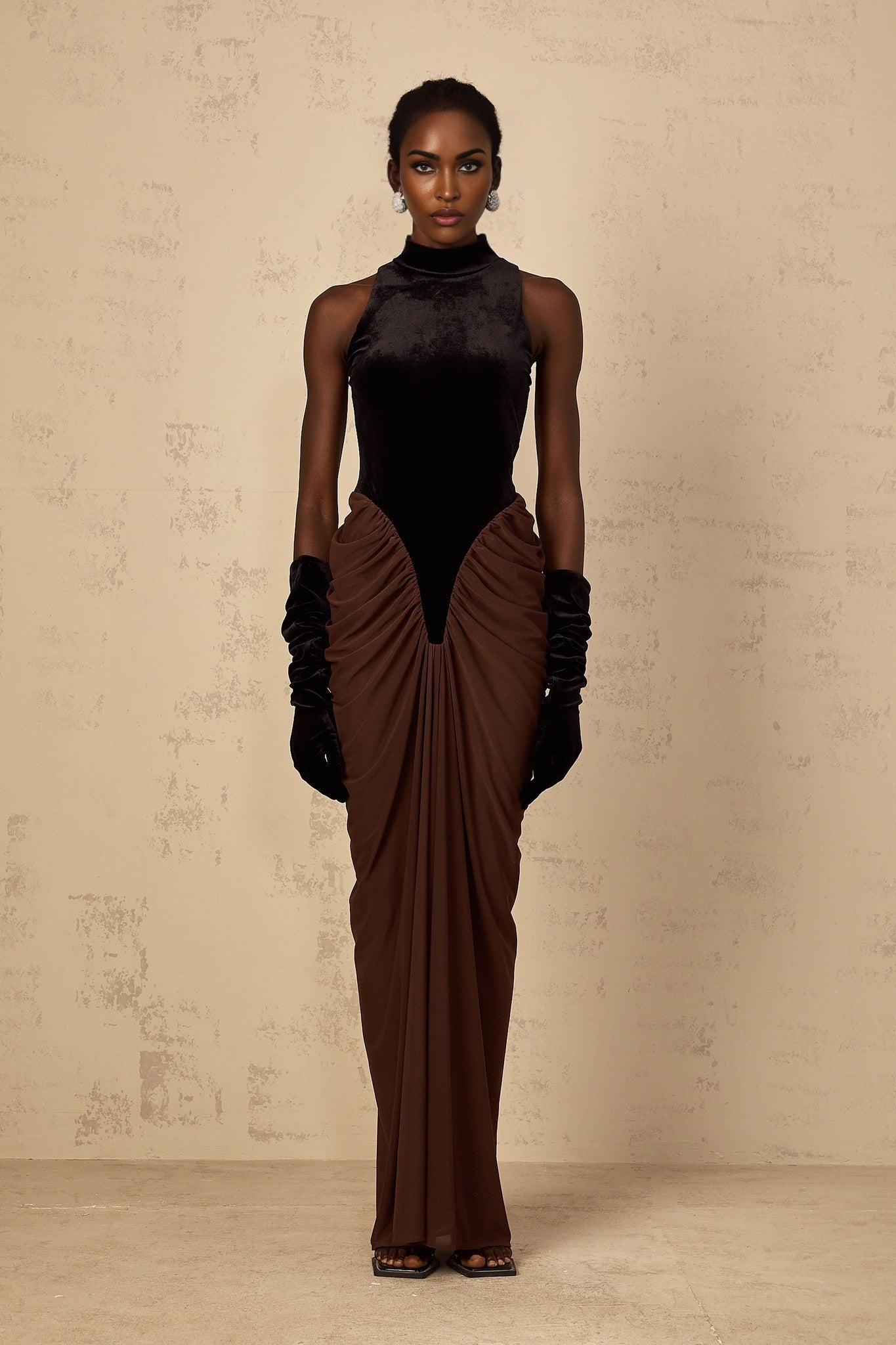 A long brown dress with velvet panels and ruched detailing named Mathilde