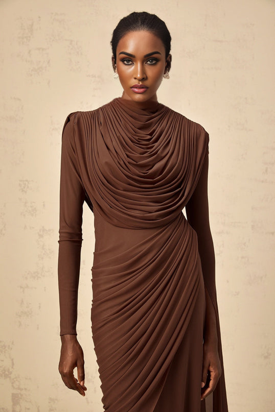 A long brown maxi dress with shirred detailing and draped fabric creating an elegant flowing silhouette